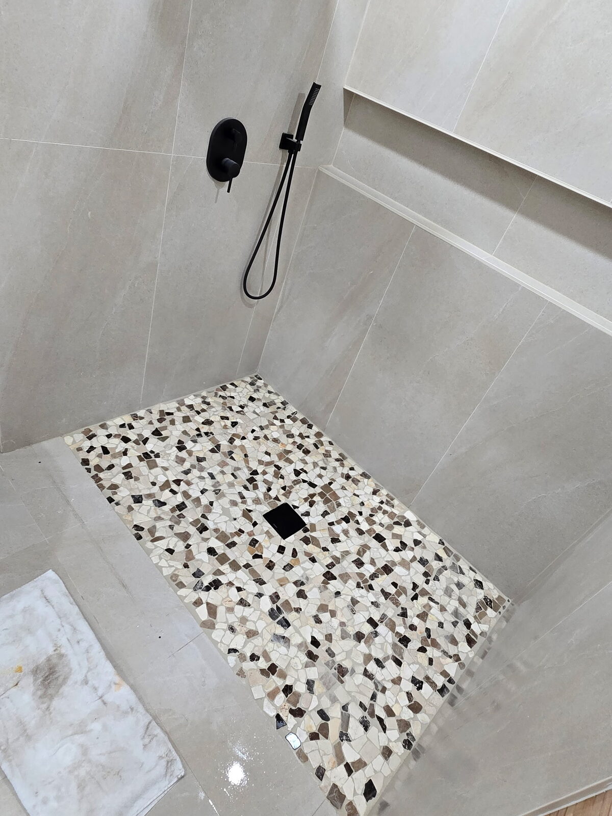 Tiled shower with pebble mosaic floor